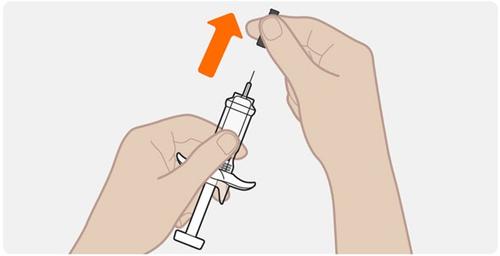Mano che tiene una siringa pre-riempita con ago esposto e un tappo nero in prossimit&agrave; della punta dell