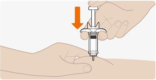 Siringa pre-riempita con ago rivolto verso il basso e mano che preme sulla superficie della pelle per l