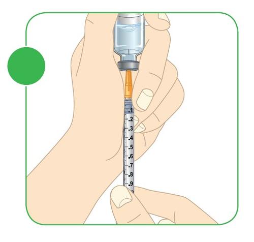 Mano che tiene una siringa piena con un flacone di medicinale collegato all