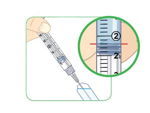 Siringa preriempita con scala graduata e ago trasparente che inietta liquido in un punto bluastro evidenziato da un cerchio verde