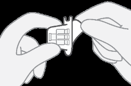 Due mani che tengono e manipolano un dispositivo medico bianco con elementi a scatto e una forma complessa