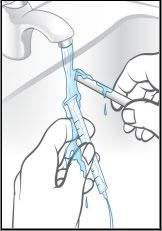 Mano che tiene una siringa sotto il flusso d