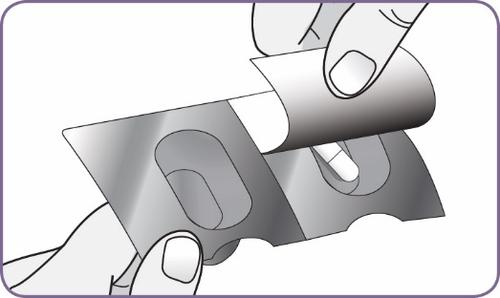 Mani che rimuovono una pellicola protettiva da un blister contenente una compressa bianca di forma ovale