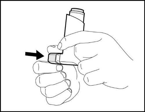 Mano che tiene un dispositivo penna per iniezione con una freccia nera che indica la posizione del pulsante di rilascio