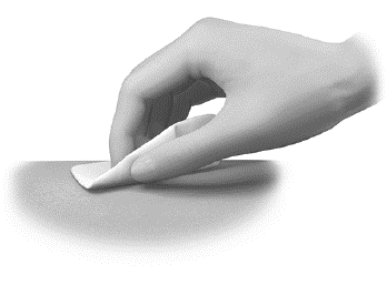 Mano che applica un cerotto adesivo bianco su una zona cutanea chiara e liscia