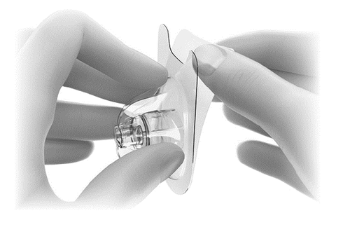 Mani che applicano un cerotto medicinale trasparente con un dispositivo cilindrico centrale e un