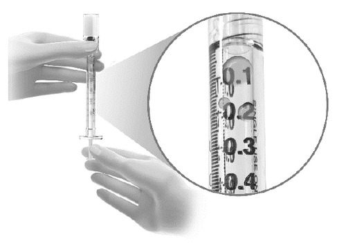 Mani che tengono una siringa trasparente con scala graduata da 01 a 04 e ago, dettaglio ingrandito sulla graduazione 02