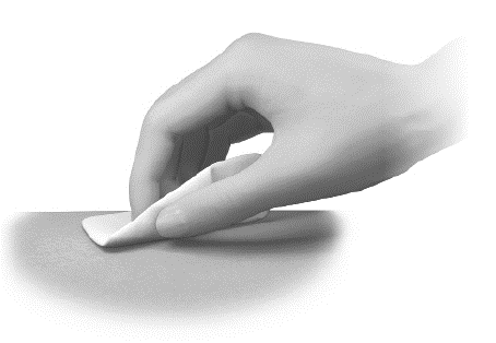 Mano che applica un cerotto adesivo bianco su una superficie cutanea chiara con pressione