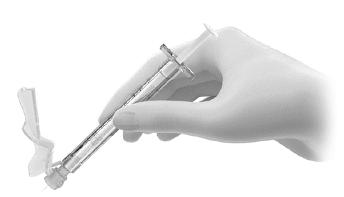 Mano che tiene una siringa preriempita con ago protetto da cappuccio di sicurezza trasparente