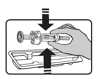 Siringa preriempita con stantuffo retratto e ago esposto tenuta in mano sopra un vassoio di plastica trasparente frecce indicano la direzione