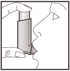 Mano che tiene un inalatore vicino alla bocca aperta del paziente per l