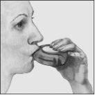 Person holding a mouth inhaler with lips sealed around the mouthpiece