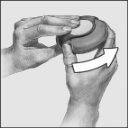 Hand holding a white and gray oval device with a white arrow indicating the direction of rotation