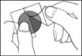 Two fingers holding a dark circular device with a front opening and a line indicating its use