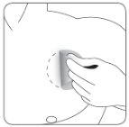 Hand applying pressure with a cotton swab on the injection site on the abdominal skin