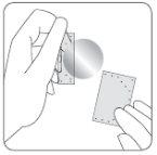 Hand applying a greyish medicinal patch on the skin with another loose piece on the side