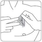 Hands applying a greyish medicinal patch on the arm skin with a small circle visible